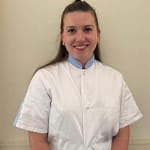 Portrait de l’Ostéopathe Lyon 8 en blouse blanche.